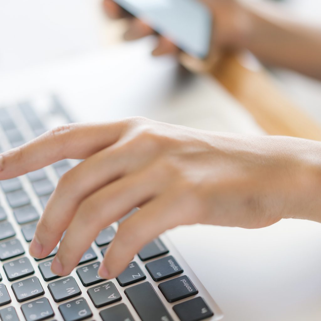 business woman hand with financial charts and mobile phone over laptop on the table .